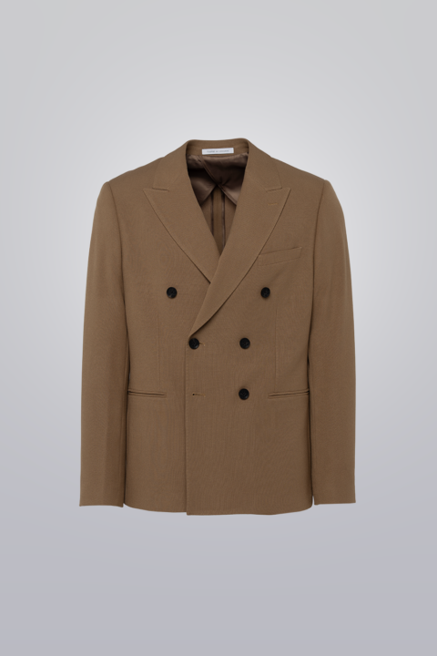 Double breasted blazer in tan made from TR poly viscose fabric. Features peak lapel, six buttons, and pipped pockets. Unconstructed for comfort.