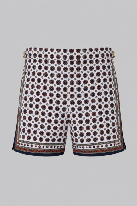 Orange and Navy silk swim short for men featuring an all-over geometric print, adjustable side straps, button and zipper closure, metal hardware, zippered back pockets, and mesh lining by Clubman by Leonardo.